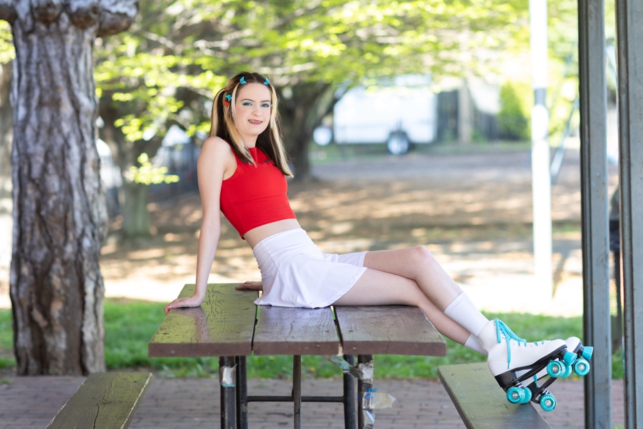 Young woman sitting on picnic table.